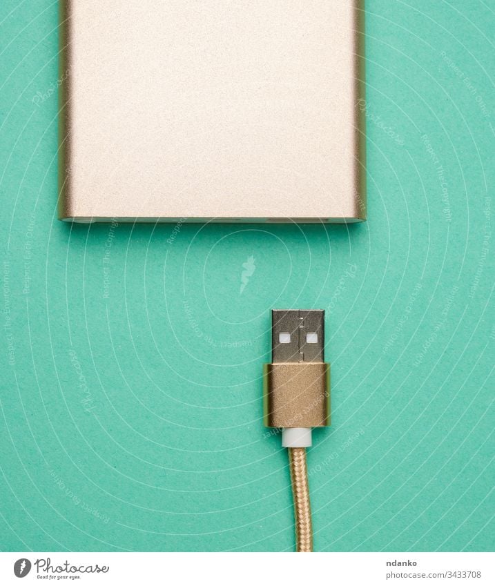 goldenes netzteil und kabel mit usb-anschluss zum aufladen mobiler geräte auf grünem hintergrund Kabel Schnur Hintergrund Bank Ladegerät Energie Mobile Kraft