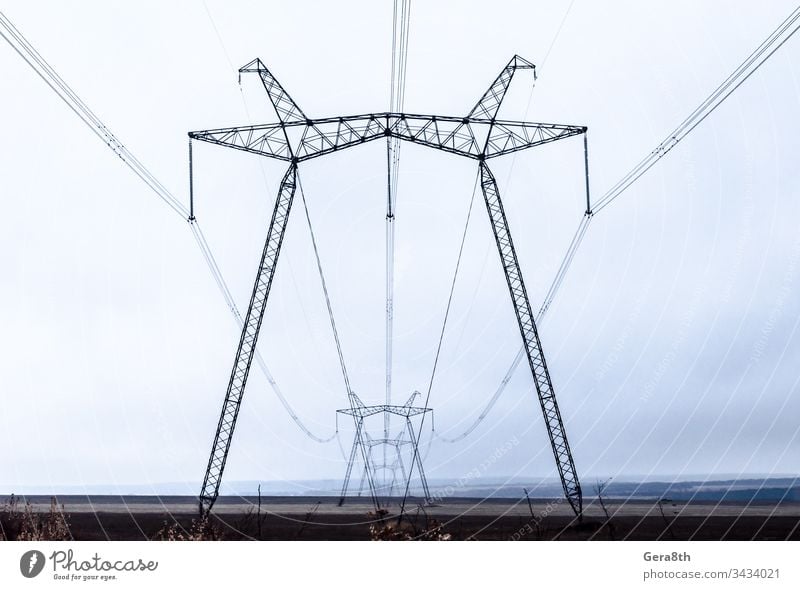 Hochspannungsleitungen in der Perspektive Herbst Wolken Konstruktion Schnur dunkler Himmel elektrisch Energie Abend industriell Linien Metall Pole Kraft