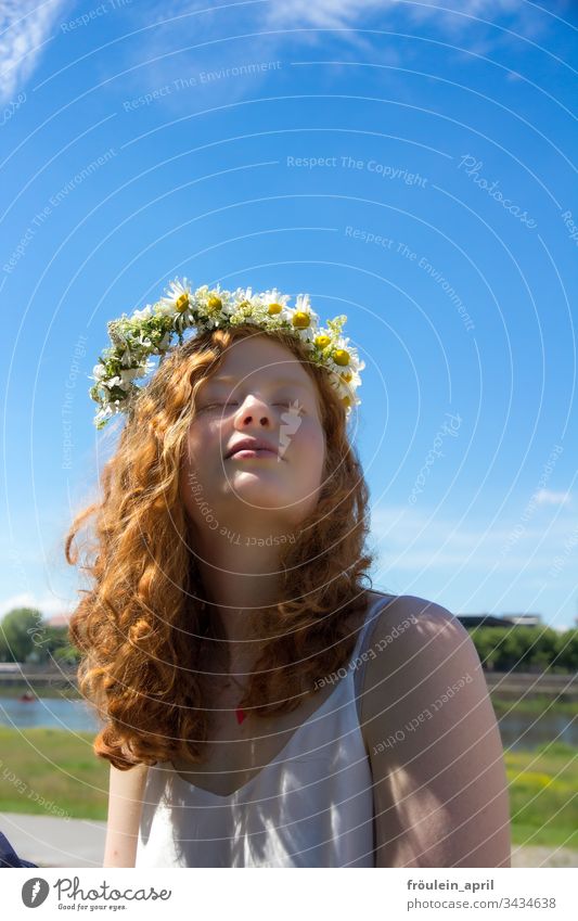 rothaarige Frau mit Blumenkranz im Haar Sonne Entspannung Margarithen Ruhe Sommer Tageslicht genießen junge Frau mittlere Tiefenschärfe Natur Erwachsene feminin