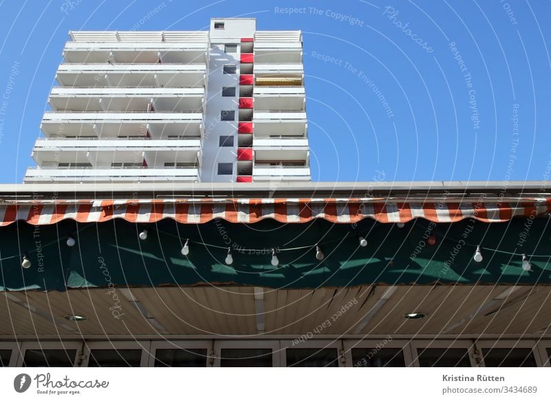 lichterkette, markise und hochhaus gebäude balkon balkone fassade architektur immobilie zuhause zu hause wohnen leben mieten wohnung wohnungen balkonien sonne