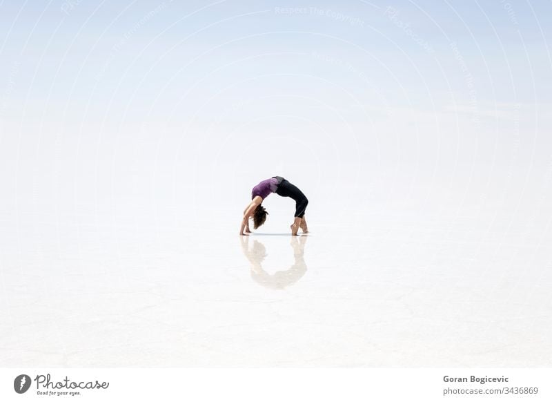 Junge Frau in der Salar de uyuni-Salzfläche in Bolivien Kunstturnen altiplano Höhe amerika Anden Gegend blau hell Windstille Farbe Tag wüst Ausflugsziel