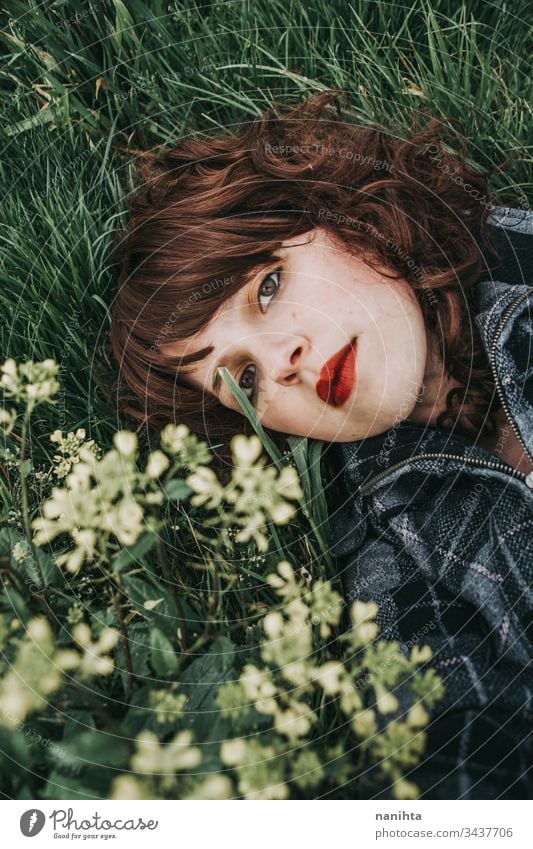 Junge schöne Frau ruht in einem Blumenfeld Porträt Stimmung Frühling dunkel romantisch Nostalgie Gefühle grün brünett hübsch Gesicht weiß Kaukasier Natur