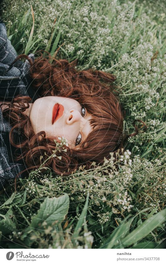 Junge schöne Frau ruht in einem Blumenfeld Porträt Stimmung Frühling dunkel romantisch Nostalgie Gefühle grün brünett hübsch Gesicht weiß Kaukasier Natur