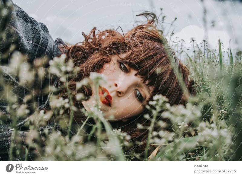 Junge schöne Frau ruht in einem Blumenfeld Porträt Stimmung Frühling dunkel romantisch Nostalgie Gefühle grün brünett hübsch Gesicht weiß Kaukasier Natur