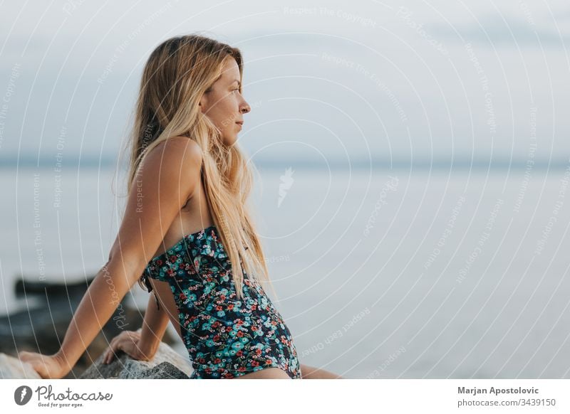 Junge Frau genießt Sonnenuntergang am Strand allein schön Windstille Küste Morgendämmerung verträumt Abenddämmerung genießen Genuss Freiheit Zukunft Mädchen