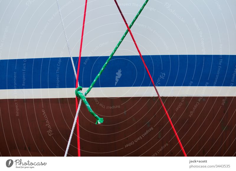 Seile und Knoten an einer gestreiften Bootswand Schiffswand Tau Detailaufnahme Zusammenhalt Sicherheit Ordnungsliebe maritim Strukturen & Formen Muster Metall