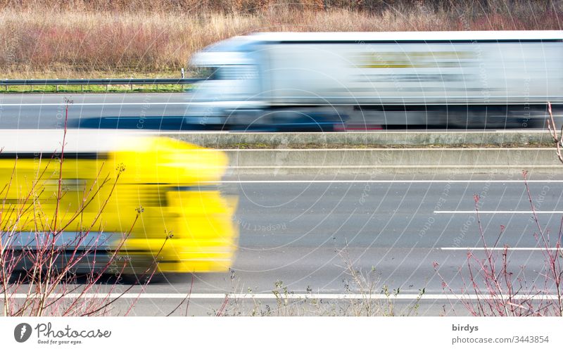 Fahrende Lastkraftwagen auf einer Autobahn, Bewegungsunschärfe, Logistik, Versorgung der Bevölkerung mit Dingen des alltäglichen Bedarfs lkw