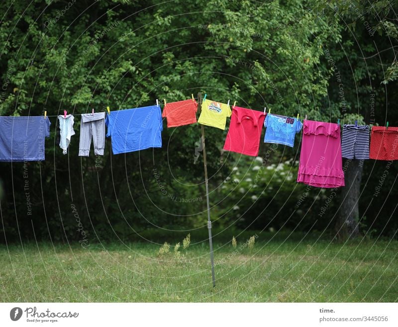 Buntwäsche hoch hängen schutz perspektive linien schönes wetter zusammen gemeinsam wäscheleine wald baum garten wiese rock hose t-shirt grün bunt blau rot