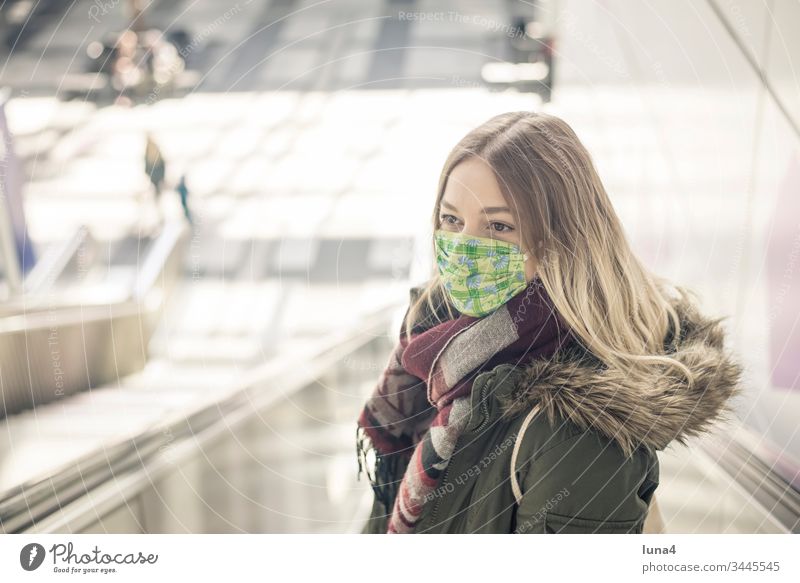 junge Frau mit Mundschutz in der Stadt Maske Atemschutzmaske Schutzmaske Virus Coronavirus besorgt Viren Pandemie Ansteckung bedrohlich Grippe anstecken