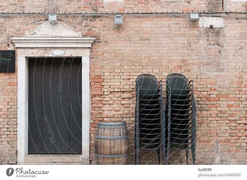 gestapelte Stühle mit Weinfass und historischer Fassade Stapel Backstein Backsteinwand Altstadt geschlossen Stuhl Stuhlgruppe Stuhlstapel minimalistisch