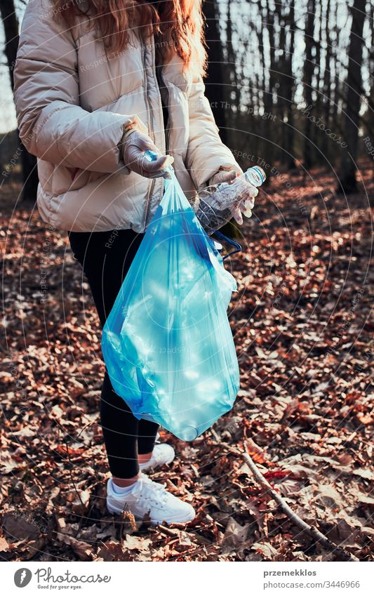 Junge Frau räumt einen Wald auf. Freiwillige Helferin beim Einsammeln von Plastikmüll in Säcke. Konzept der Plastikbelastung und zu viel Plastikabfall. Umweltproblematik. Umweltschäden. Verantwortung für die Umwelt. Echte Menschen, authentische Situationen