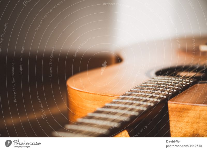 Gitarre Musikinstrument liegt auf dem Boden und wird vom Sonnenlicht angestrahlt liegen fußboden Pause Auszeit Textfreiraum oben Schatten Licht