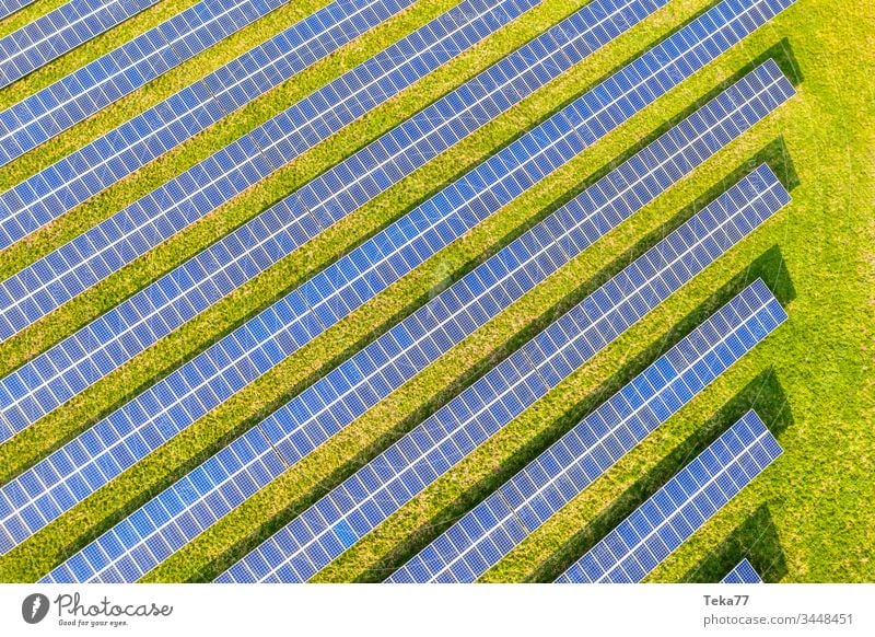 ein moderner Solarzellenpark von oben solar Sonne Sonnenstrahlen blau weiß heiß gelb Gras Wiese grün Wolken Betrachtungen Lithium moderne Solarzelle