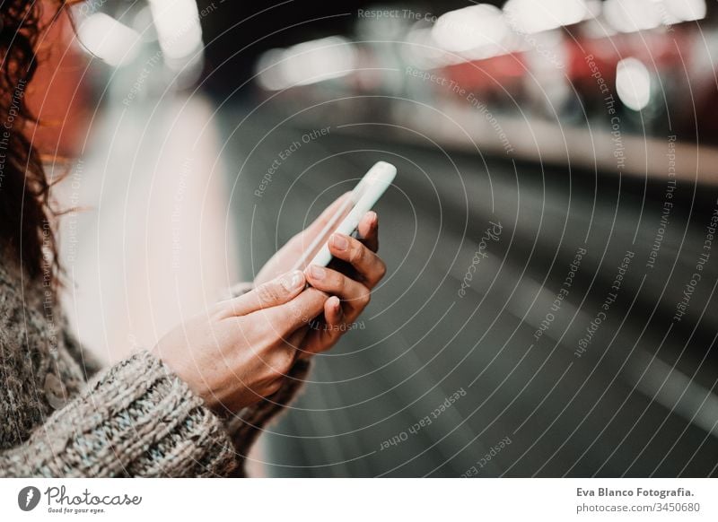 junge, schöne Frau am Bahnhof mit dem Handy, bevor sie den Zug erreicht. Reise-, Technologie- und Lifestyle-Konzept reisen Station bewegend Kaukasier Madrid