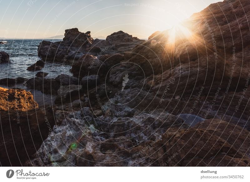 Felsige Küste bei Sonnenuntergang Felsenküste Stein Himmel Umwelt Tourismus Wasser Menschenleer Sommer natürlich Bucht Tag Horizont Licht Mittelmeer orange