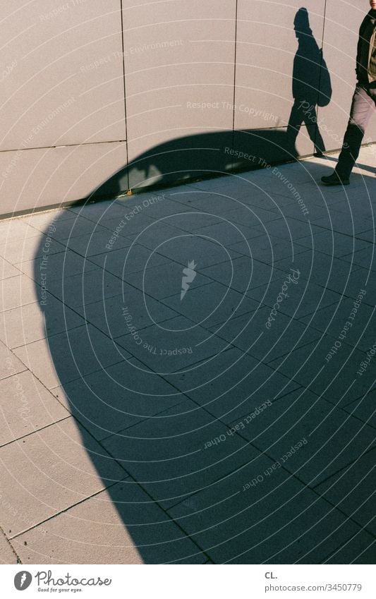 fußgänger und der schatten eines autos Auto Fahrzeug PKW Verkehrswege gehweg Wand Mann gehen Schatten Fußgänger Schattenspiel Wege & Pfade Außenaufnahme Straße