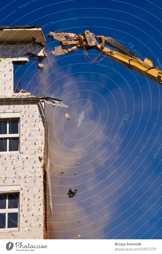 Abbruch eines Gebäudes mit einem Kran vor blauem Himmel Beruf Großstadt Bauherren alt Haus abbrechend erdrücken Außenseite Architektur Müll Business staubig