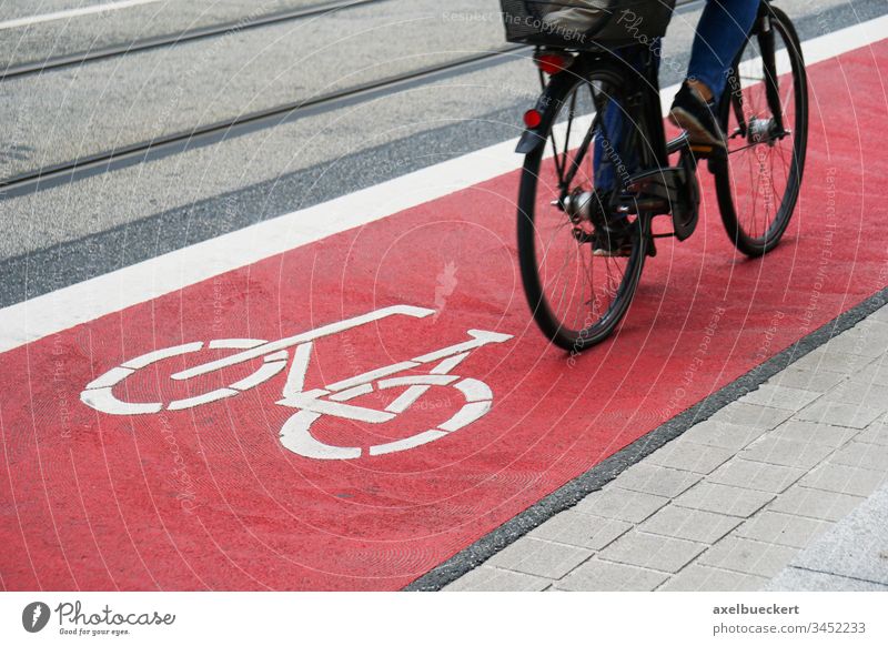 Radspur Fahrradweg Fahrspur Weg Radfahrer Fahrradfahren Radweg Verkehr Straße rot Großstadt Symbol Zeichen Radfahren Arbeitsweg Asphalt Sicherheit Person urban