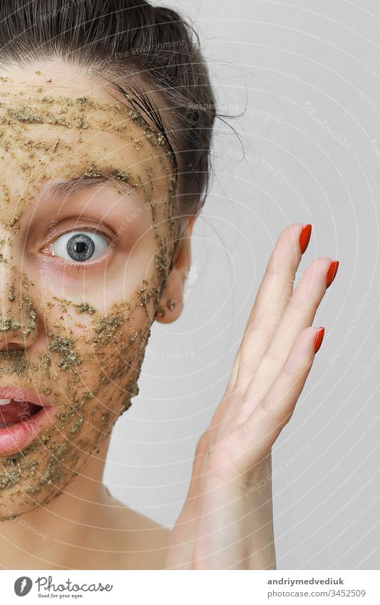 Hautpflege. Cosmetic Day. junges Mädchen in häuslicher Form, die Haare mit den Händen oben zusammengerafft. Mit ökologischer, pflanzlicher, natürlicher Maske, grün im Gesicht. Vorderansicht.