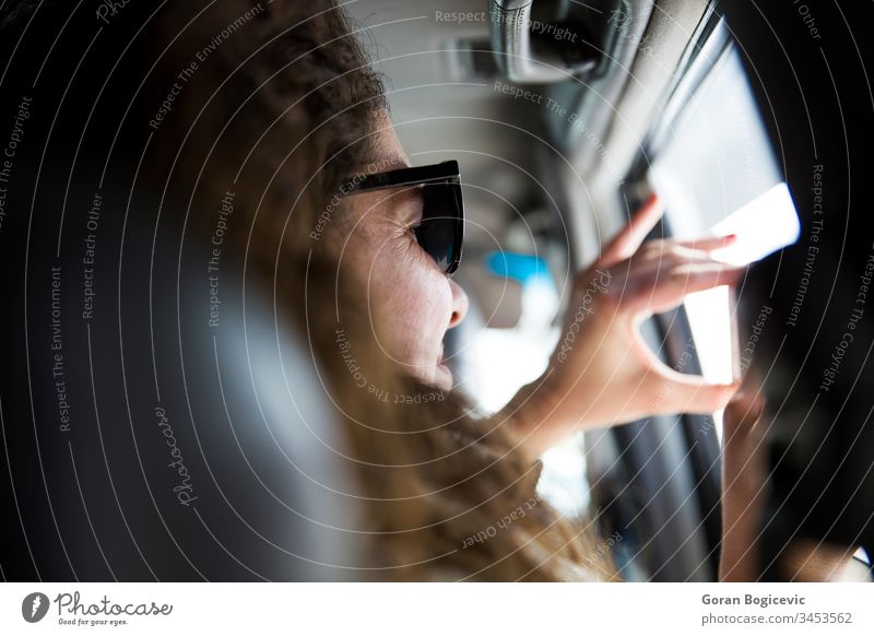 Hübsche junge Frau, die auf einer Autoreise ein Foto mit einem Mobiltelefon aus dem Inneren eines Fahrzeugs macht Sitz Blick genießend Ansicht Tag Passagier