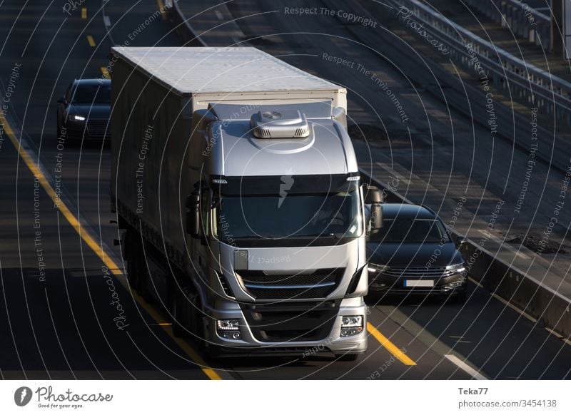 ein moderner grauer Lastwagen, der auf einer Autobahn fährt PKW Ladung Großstadt abschließen Wolken Globalisierung Licht Lichter Ebene Straße Straßen Verkehr