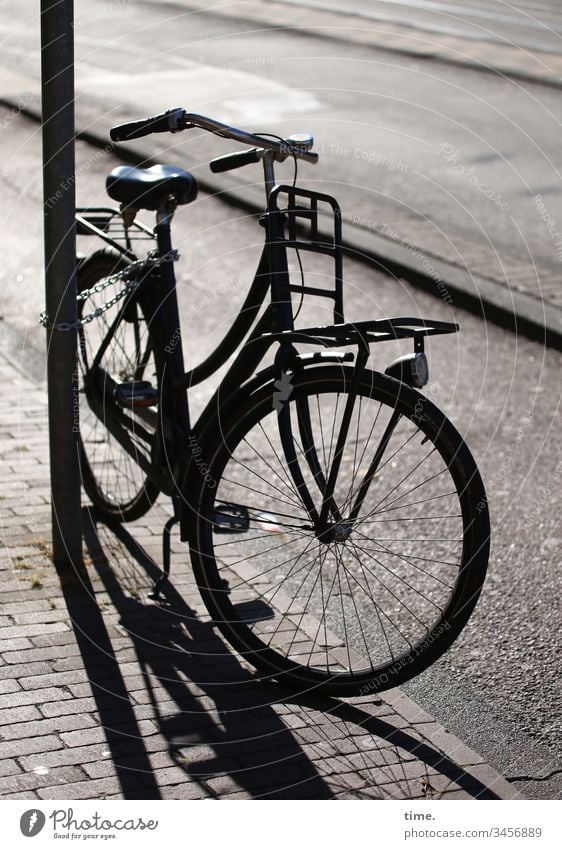 Fiets an Fietspad sonnenlicht morgens linien parallel gegenlicht straße laternenpfahl fahrrad fahrradweg bürgersteig abgestellt pflasterstein gepflastert