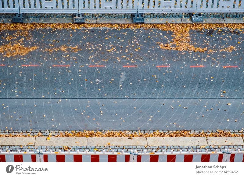 Draufsicht auf die Straße im Herbst mit Sicherheitszaun für Straßenarbeiten Minimalismus Park urban Asphalt Hintergrundbild Barriere Vogelschau Konstruktion