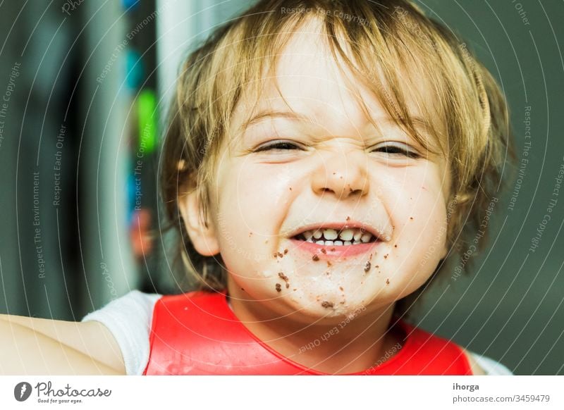 Porträt bezauberndes Kind isst Schokolade Biskuitkuchen Attribut Baby Hintergrund Lätzchen Junge braun Kuchen Bonbon Kindheit schoko niedlich lecker wüst