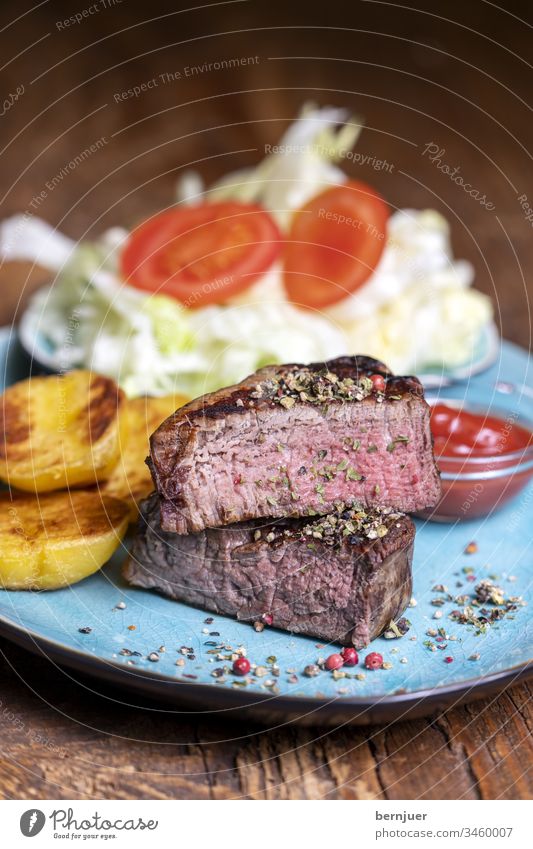 gegrilltes Steak auf dem Teller Rinderfilet Scheibe halb Hälfte habliert Kartoffel Salat Tomate mittel ketchup fettlos grillen Abendessen Mahlzeit Salz Kraut