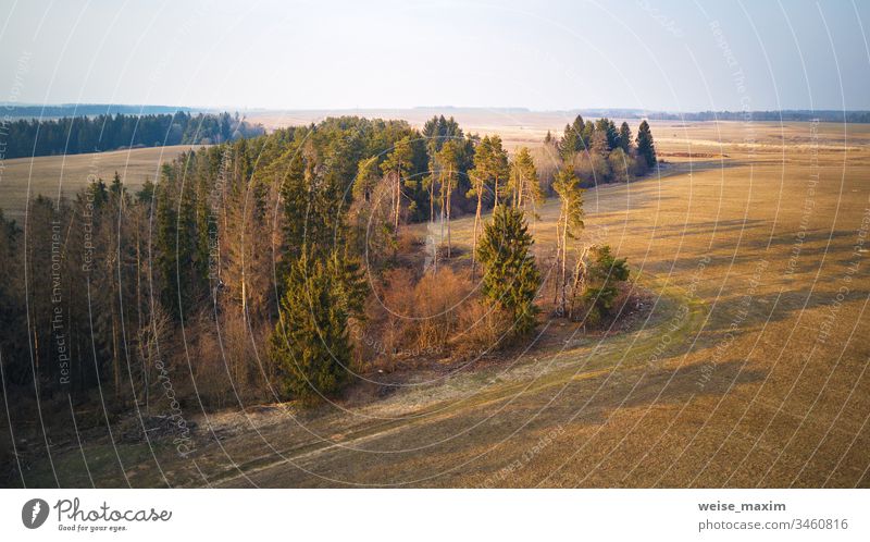 Sonnige Abendszene März-April. Ruhiger Frühlings-Sonnenuntergang auf dem Land Panorama Antenne Feld Ackerbau kultiviert Szene gepflügt ländlich industriell