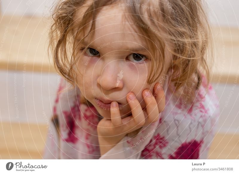 Nahaufnahme einer verärgerten kleinen Blondine, die ihr Kinn in der Hand hält bezaubernd allein wütend Schlechte Laune schön gelangweilt blond Kind Kindheit