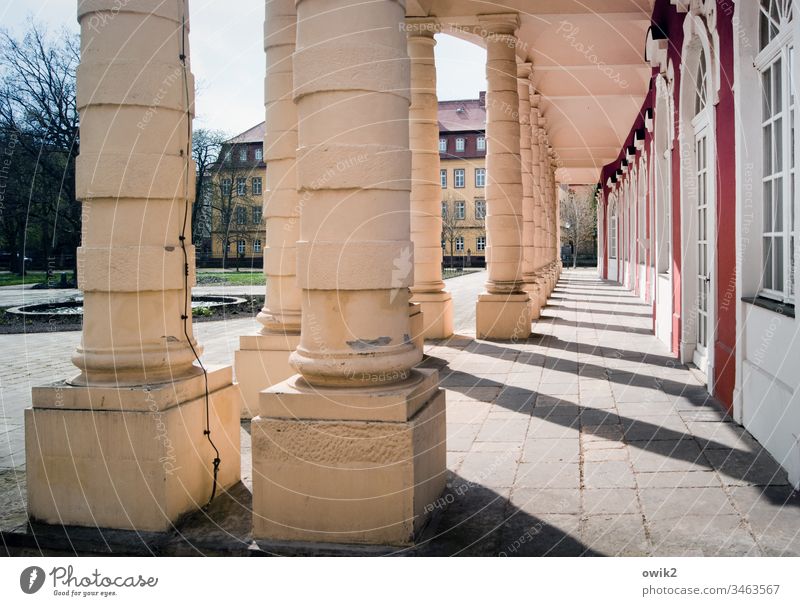 Kolonnaden Säulen Schloss Gang lustwandeln repräsentativ Architektur Gebäude Menschenleer Schatten Licht alt Bauwerk Sehenswürdigkeit historisch Stein Fassade