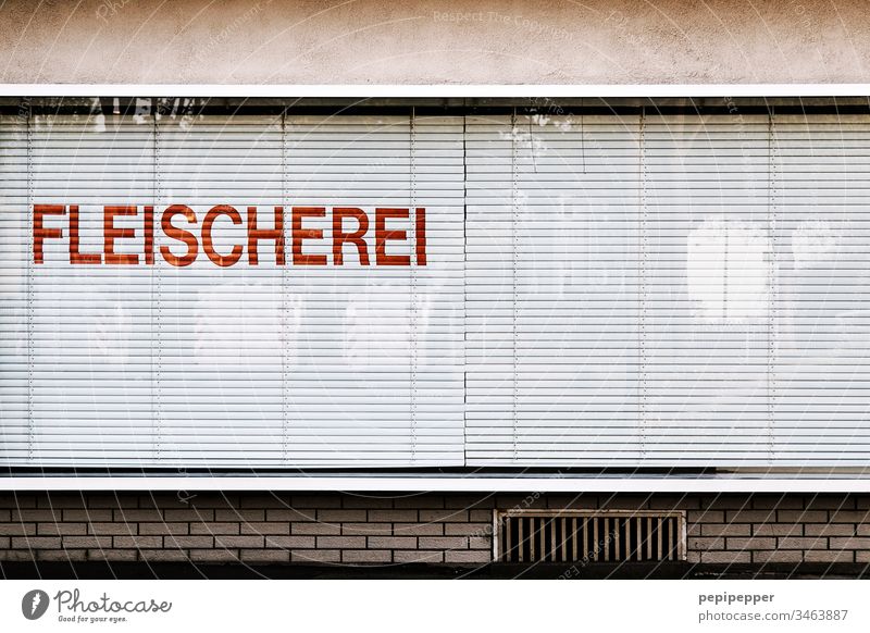 Schaufenster Fleischerei Fenster Ladengeschäft Menschenleer Außenaufnahme Haus Fassade Gebäude Gedeckte Farben Wand alt Fensterscheibe Buchstaben Wurstwaren