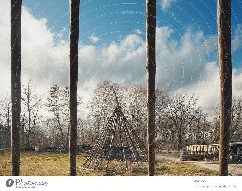 Durch die Stäbe Tipi Tipidorf Lausitz Gerüst Gestell Bäume Himmel Wolken Zeltstangen Balken Holz lang dünn leer Außenaufnahme Menschenleer Farbfoto