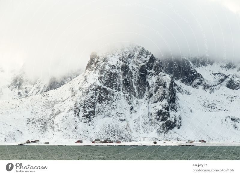 kleines Dort am Fjord vor verschneiten Bergen Lofoten Norwegen Skandinavien Winter Berge u. Gebirge Schneebedeckte Gipfel kalt Küste Meer Schneelandschaft Dorf