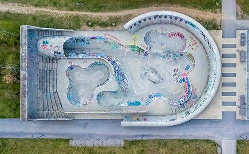 Ein von einer Drohne erschossener Skaterplatz in vertikaler Ansicht. Schlittschuh Gericht Dröhnen Antenne Sport Park Architektur nach unten beton Tag Morgen