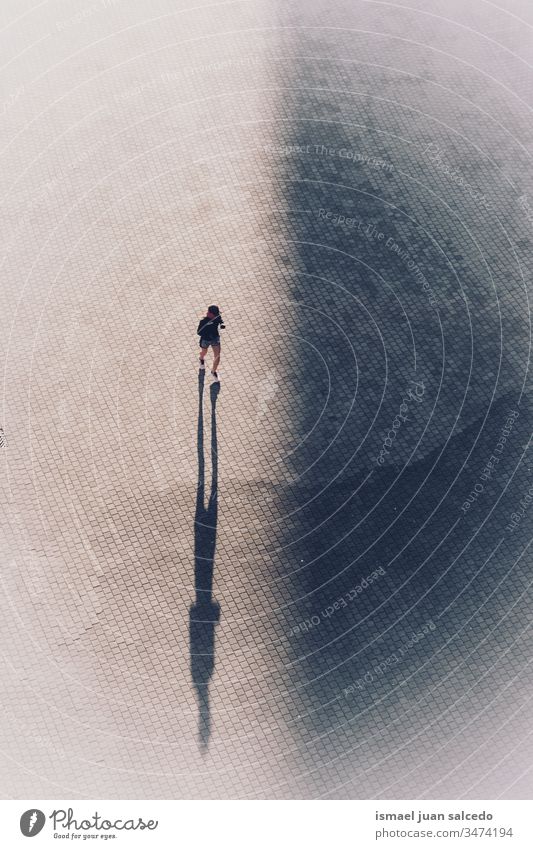 Frau läuft auf der Straße in der Stadt Bilbao Spanien Person rennen Läufer Sport Straßenfotografie im Freien Schatten Silhouette Großstadt Übung trainiert.