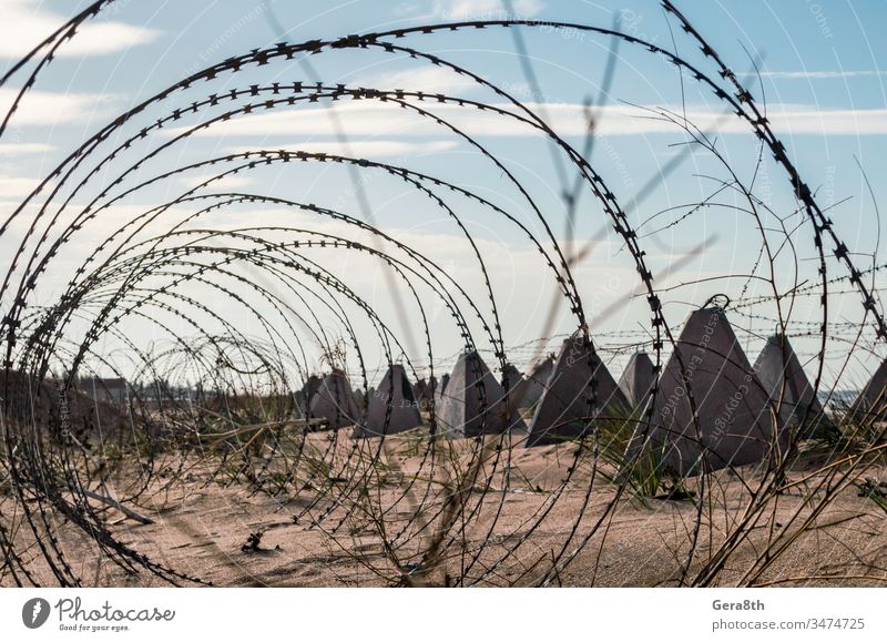 Stacheldraht und Beton-Militärzaun am Strand nahe dem Meer auf der Krim Russland Ukraine Annektierung Armee Verbot mit Stacheln versehen Barriere blau Borte