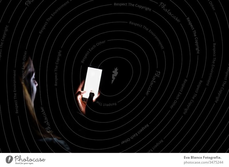 junge Frau zu Hause, die ein Mobiltelefon benutzt. Nachtzeit Handy heimwärts Bildschirm dunkel sich[Akk] entspannen Technik & Technologie Lifestyle Freizeit