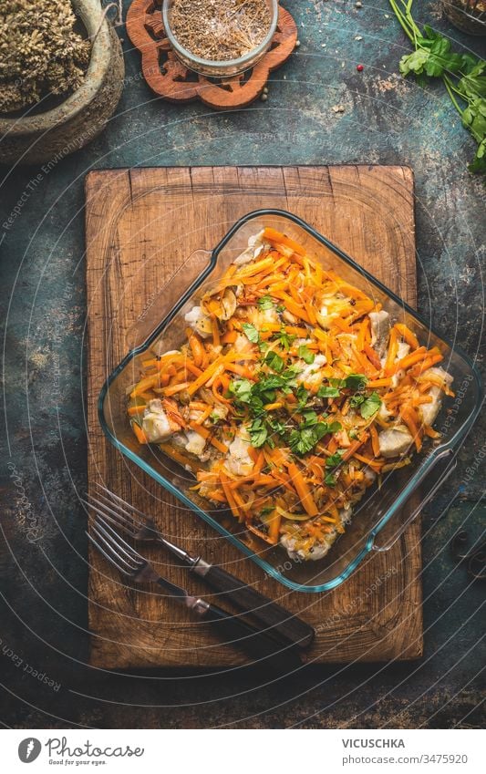 Leckeres Fischgericht mit Gemüsesauce auf Küchentischhintergrund mit Gabeln. Ansicht von oben.  Konzept der gesunden Hausmannskost. Hausgemachte Küche