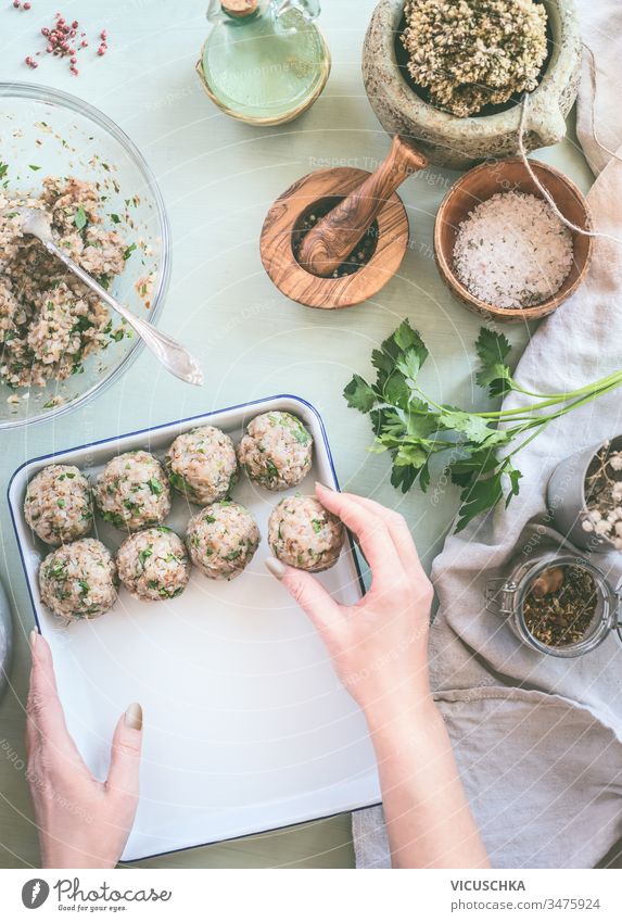 Weibliche Hand macht Buchweizenkugeln auf Küchentischhintergrund mit Kräutern und Gewürzen, Draufsicht. Gesundes hausgemachtes Essen Frau machen Bälle Tisch