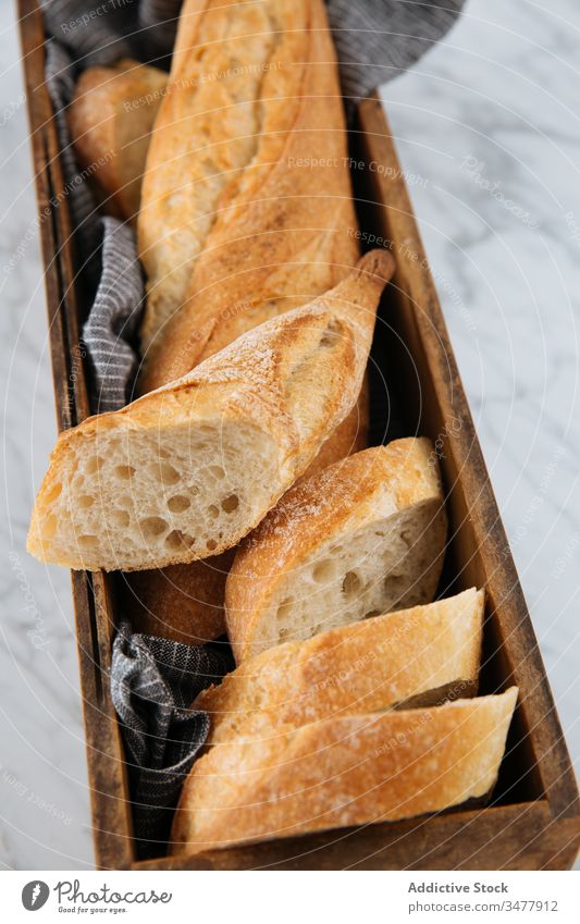 Frisch geschnittenes Brot auf Holztablett Baguette frisch Scheibe Tablett Tisch Bäckerei Brotlaib Kruste selbstgemacht Kunstgewerbler hölzern Murmel