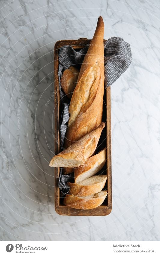 Frisch geschnittenes Brot auf Holztablett Baguette frisch Scheibe Tablett Tisch Bäckerei Brotlaib Kruste selbstgemacht Kunstgewerbler hölzern Murmel