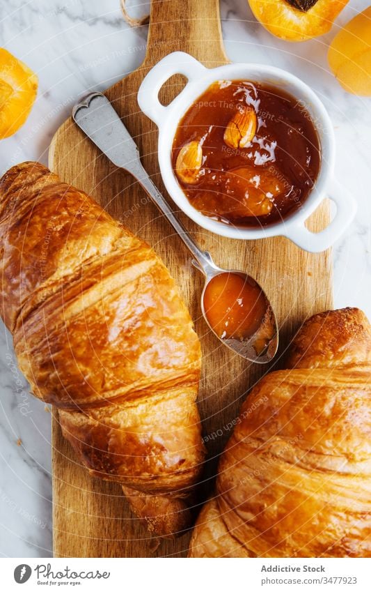 Croissant und Aprikosenmarmelade auf Holzbrett Marmelade Gebäck Frühstück backen frisch natürlich Morgen Lebensmittel dienen lecker geschmackvoll Mahlzeit