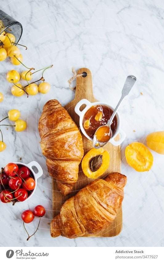 Croissant und Aprikosenmarmelade auf Holzbrett Marmelade Gebäck Frühstück backen frisch natürlich Morgen Lebensmittel dienen lecker geschmackvoll Mahlzeit