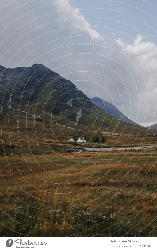 Einsames Haus im Bergtal bei bedecktem Himmel Berge u. Gebirge Grasland einsam wolkig Cottage Einsamkeit ländlich Hochland Landschaft Natur Schottland reisen