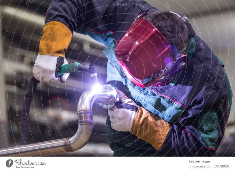 Industriearbeiter beim Schweißen in einer Metallfabrik. Schweißer Arbeiter inox Stahl Tube Kunsthandwerker industriell Handwerk Herstellung Maschinenbau