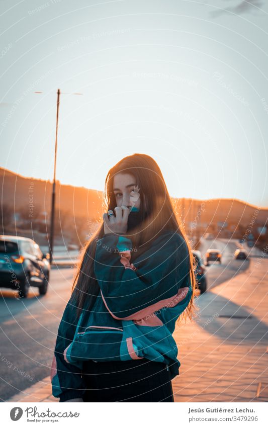 Mädchen mit Oldtimer-Kleidung mit Autos und einem schönen Sonnenuntergang im Hintergrund Leben altehrwürdig Vintage-Mädchen Porträt Straße Model niedlich