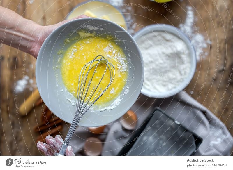 Gesichtslose Frau bereitet Eier mit Schneebesen in der Küche zu Koch Bestandteil Schalen & Schüsseln Holztisch Prozess Lebensmittel vorbereiten frisch Rezept