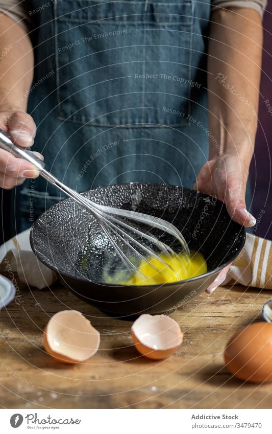 Gesichtslose Frau bereitet Eier mit Schneebesen in der Küche zu Koch Bestandteil Schalen & Schüsseln Holztisch Prozess Lebensmittel vorbereiten frisch Rezept